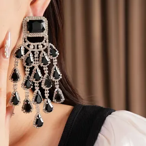 Detailed macro view of luxury silver rhinestone tassel earrings with black waterdrop stones