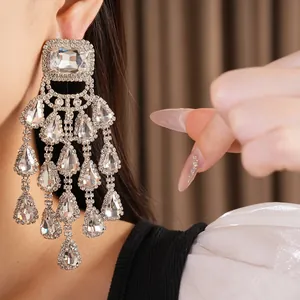 Close-up of glamorous rhinestone chandelier earrings with teardrop crystal tassels.