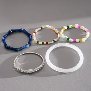 Set di cinque braccialetti alla moda con acrilico bambù blu e motivi di perline colorate.