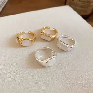 Close-up display of minimalist gold and silver plated open rings with white resin