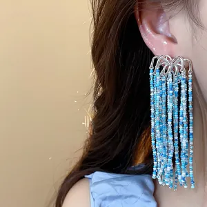 Detailed close-up view of elegant blue beaded tassel fireworks earrings worn on ear