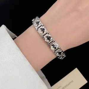 Elegant stainless steel bracelet featuring adorable enamel dog charms on a woman's wrist