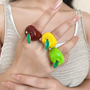 Vista detallada de tres anillos de manzana de esmalte en rojo, amarillo y verde