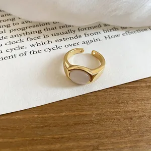 Macro detail of a minimalist 18k gold plated open ring featuring an oval resin stone