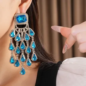 Close-up of blue teardrop tassel earrings with silver pin and sparkling rhinestones