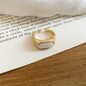 Close-up of minimalist 18k gold plated ring with elegant white resin inlay