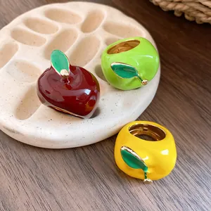 Elegante juego de tres anillos de esmalte con forma de manzana en rojo, verde y amarillo.