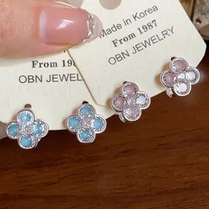 Close-up of elegant zircon flower earrings with pink and blue enamel detailing