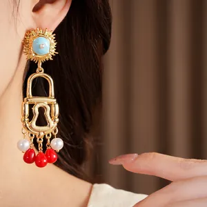 Detail view of a vintage golden lock earring with red beads and pearls worn on an ear