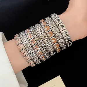 Detail view of colorful enamel puppy charms on stainless steel modular bracelets.