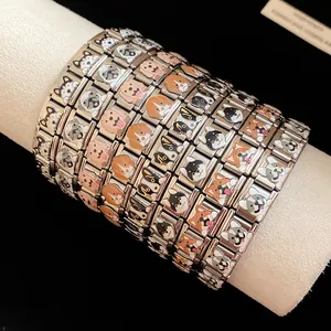 Detailed macro view of stainless steel charm bracelets with various cute enamel dog faces.