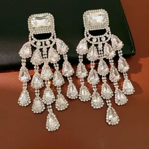 Detail view of luxury silver needle tassel earrings with sparkling water drop crystals.