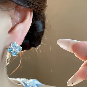 Detailed view of an elegant blue enamel flower earring with sparkling zircon accents