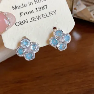 Close-up view of elegant blue flower stud earrings with sparkling zircon centers