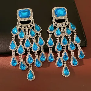 Close-up of luxurious blue teardrop crystal tassel earrings with a silver plated finish