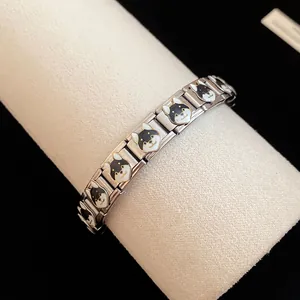 Close-up of stainless steel enamel bracelet with black shiba inu puppy pattern