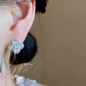 Close-up detail of an elegant pink enamel flower earring with sparkling zircons