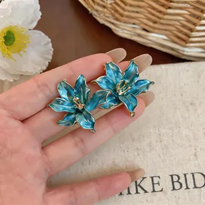 Primo piano dettagliato di eleganti orecchini a lobo a forma di fiore turchese