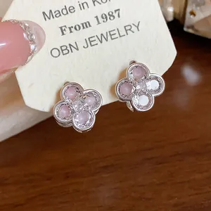 Delicate Korean flower earrings with pink enamel and sparkling zircon on branded card