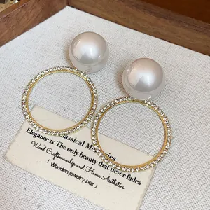 Primer plano de elegantes pendientes de perlas con círculos de strass brillantes