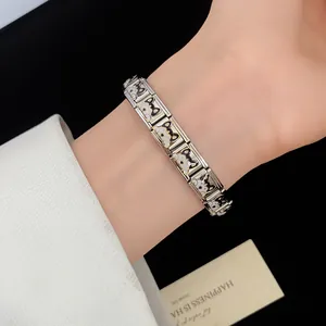 Detailed close-up of stainless steel bracelet with cute black and white puppy charms