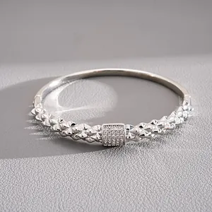 Dettaglio ravvicinato di un bracciale rigido in argento con pavé di cristalli al centro
