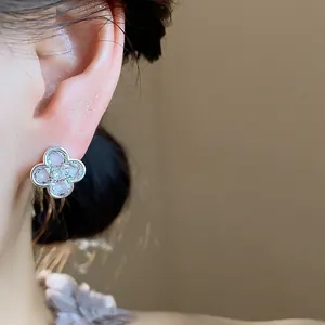 Close-up detail of elegant silver zircon flower earrings with pink enamel petals