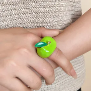 Vista detallada de un anillo de manzana en esmalte verde vibrante con detalle de hoja