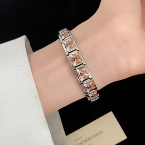 Detailed view of stainless steel enamel corgi dog charm bracelet on wrist
