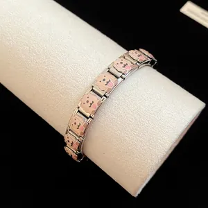 Detailed view of a stainless steel charm bracelet featuring cute enamel puppy dog patterns