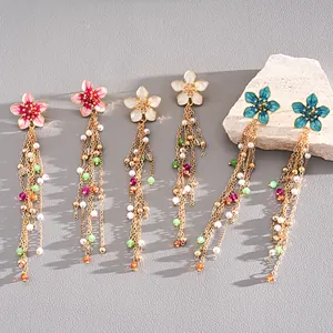 Detailed shot of three pairs of colorful flower tassel earrings with glass beads and pearls.