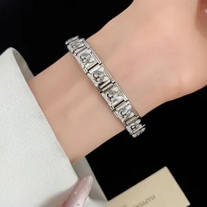 Close-up detail view of a silver stainless steel enamel dog bracelet on a female wrist.