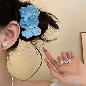 Romantic light blue fabric flower hair clip with pearl center for a seaside vacation look
