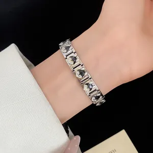 Detailed macro shot of the stainless steel link bracelet with cute enamel dog charms