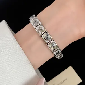 Detailed close-up of a stainless steel link bracelet featuring cute enamel pug puppy charms