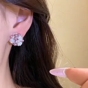Eleganti orecchini a lobo a fiore con perle di resina e cristalli su modella.
