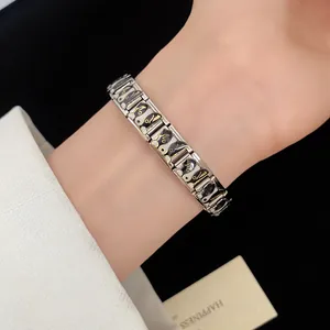 Detailed close-up of a stylish stainless steel enamel puppy bracelet on a woman's wrist