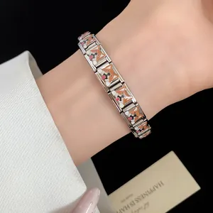 Detailed macro shot of stainless steel bracelet with corgi enamel charms