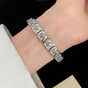 Macro view of a stainless steel fashion bracelet featuring cute enamel dog charms on a wrist