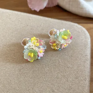 Vue détaillée de boucles d'oreilles fleurs en résine verte avec de jolies perles colorées