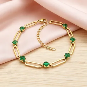 Gold-plated paperclip link bracelet featuring emerald green cubic zirconia stones