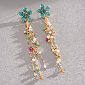Detailed view of blue enamel flower tassel earrings featuring pearls and colorful beads