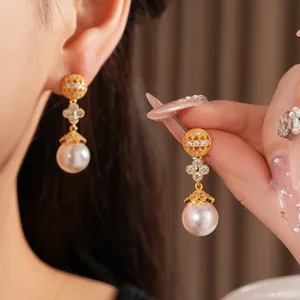 Detailed view of elegant 18k gold plated clover pearl earrings with sparkling zircons
