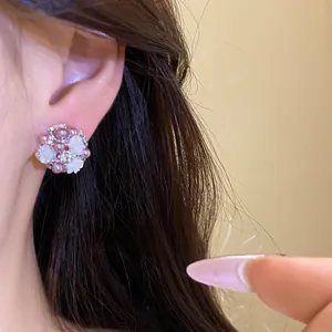 Primo piano di orecchini a lobo a fiore con perle di resina e strass