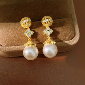 Elegant close-up view of 18k gold plated zircon clover flower earrings with pinkish pearls