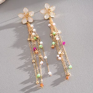 Close-up of elegant floral tassel earrings featuring colorful beads and pearls.