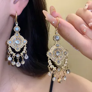Close-up of vintage palace-style gold earrings with sparkling rhinestones and wheat-ear motifs