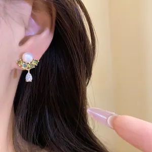Elegant pearl and green zircon stud earring with pear drop, gold-plated on model.