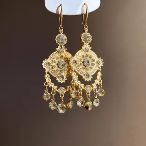Close-up view showing the intricate detail of vintage gold court style rhinestone earrings