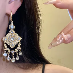 Detailed view of vintage gold royal style earrings with wheat pattern and rhinestones